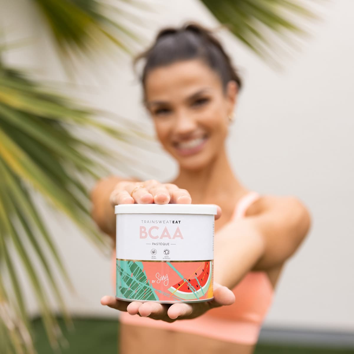 Photo de Sissy Mua qui tient les BCAA Pastèque de TSE Nutrition